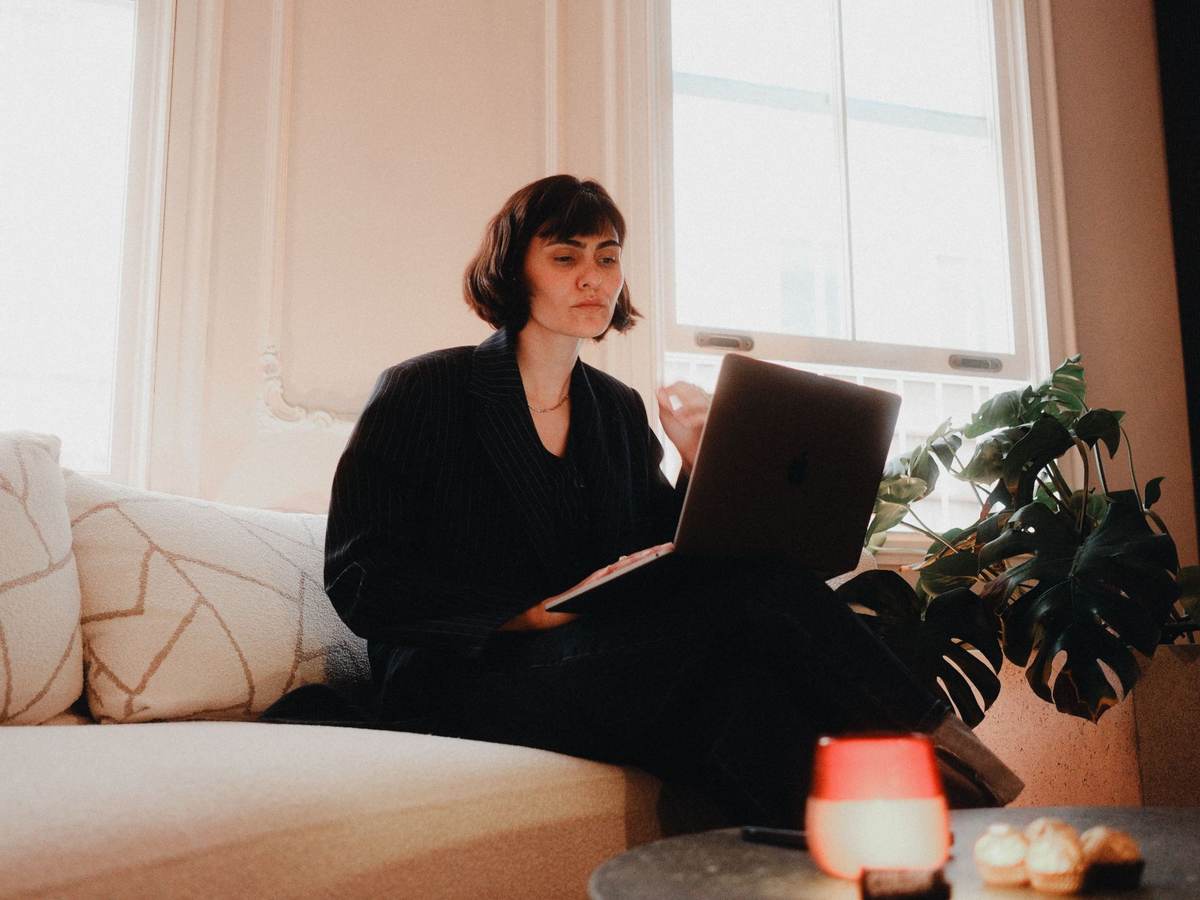 A woman working through marketing plans on a laptop, representing the strategic thinking behind a compliant health marketing campaign