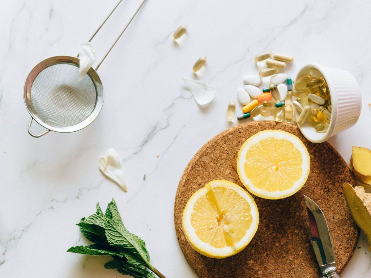 Lemon, mint, ginger and wellness supplements laid out on marble, representing the health and wellness products and services businesses market to consumers