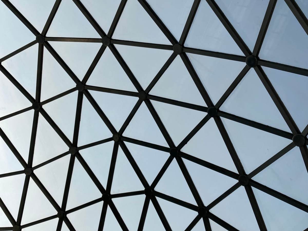 A glass and steel geodesic dome ceiling, representing the clear, well-engineered structure behind a secure software build